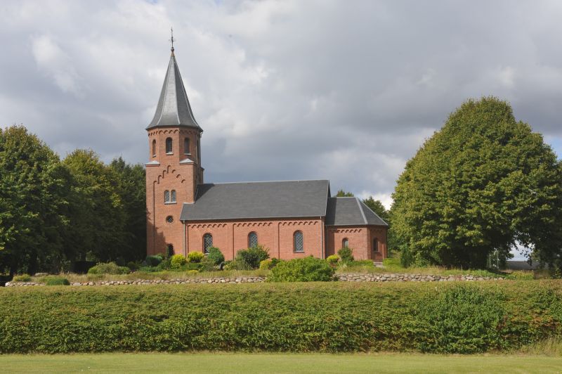 Den tidligere kirke var en romansk granitkvaderkirke, der bestod af kor, skib, våbenhus mod syd. Her nutidens kirke set fra ysd. 