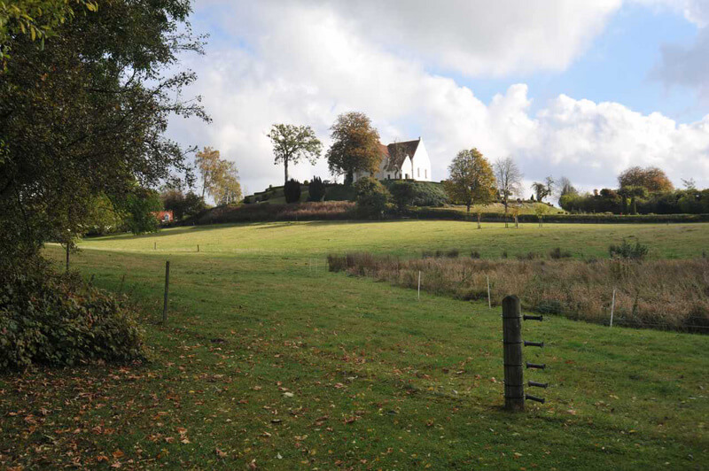 Udsigt fra SV.-enden af halvkredsvolden over Præsteengen mod Pedersborg Kirke.